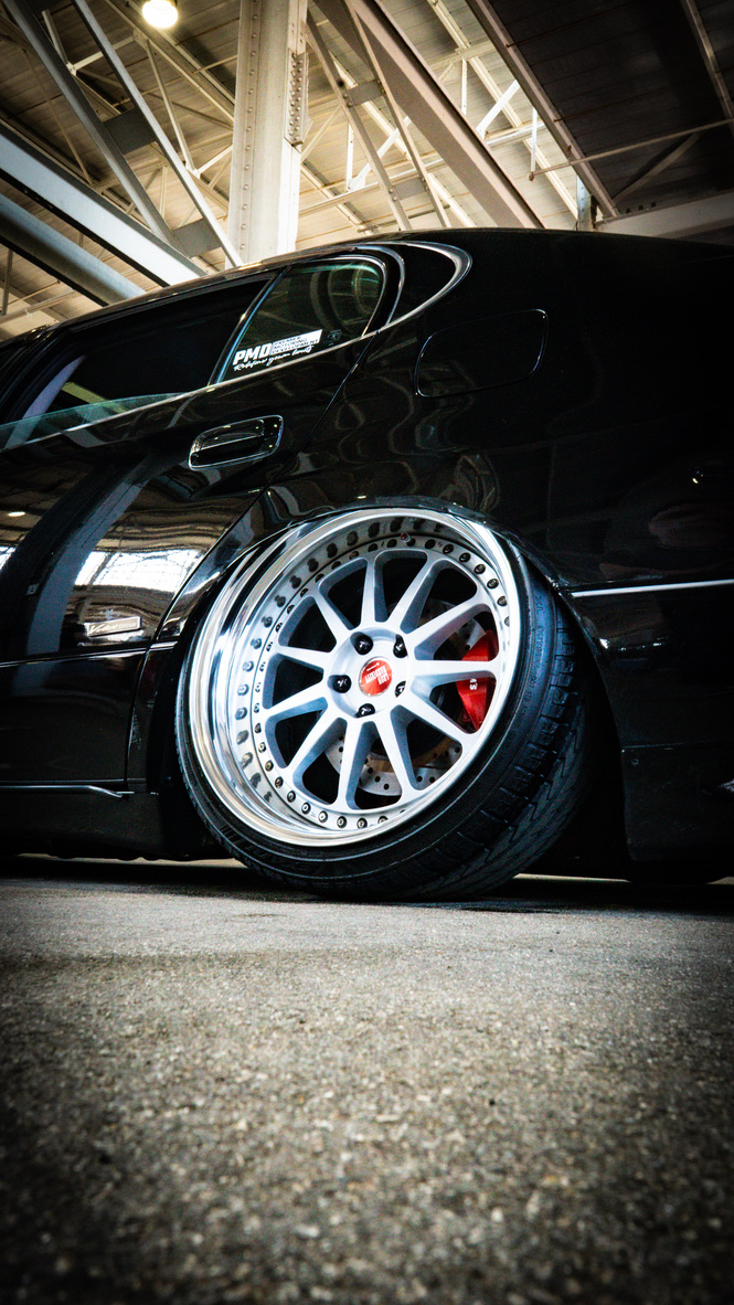 Low black sedan with polished wheel